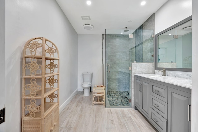 bathroom with a shower with shower door, toilet, vanity, and wood-type flooring