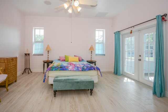 bedroom featuring ceiling fan, light wood-type flooring, and two closets