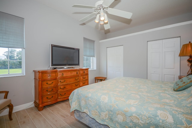 bedroom featuring two closets, ceiling fan, and light wood-type flooring