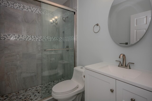 bathroom featuring walk in shower, vanity, and toilet