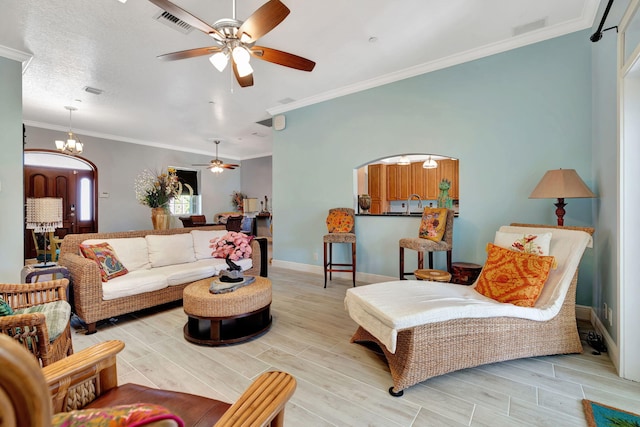 living room with ceiling fan with notable chandelier, a textured ceiling, crown molding, and sink