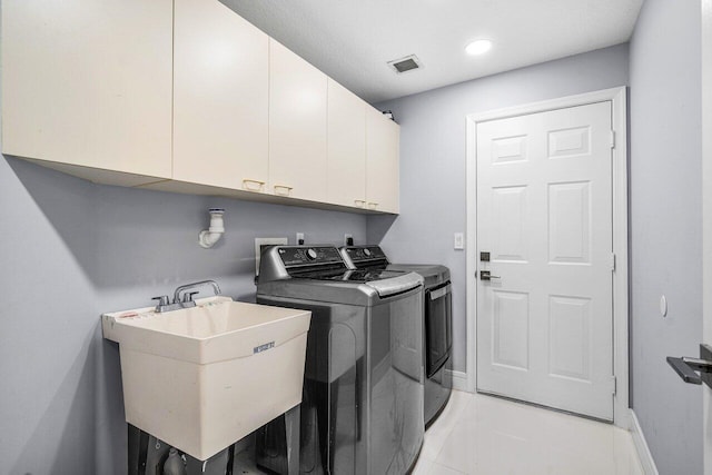 laundry room with cabinets, sink, washer and clothes dryer, and light tile patterned floors