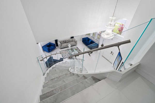 stairs with a chandelier and tile patterned floors