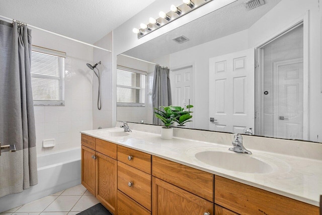 full bath with a textured ceiling, tile patterned flooring, a sink, and visible vents