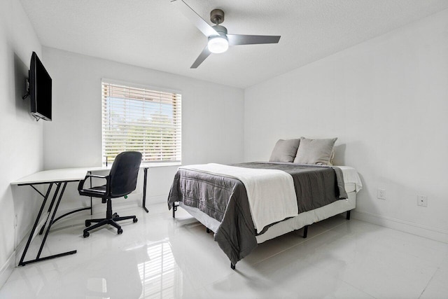 bedroom featuring ceiling fan, a textured ceiling, and baseboards