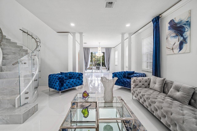 tiled living room featuring a textured ceiling and ornate columns