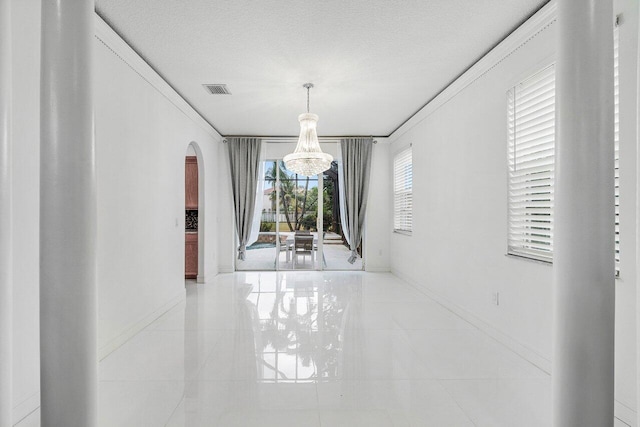 unfurnished dining area with a notable chandelier, plenty of natural light, and light tile patterned flooring