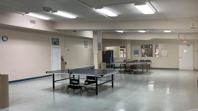 recreation room featuring a textured ceiling