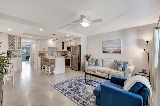 living room featuring ceiling fan and sink