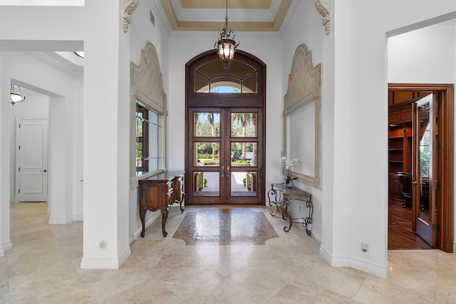 foyer entrance featuring a high ceiling, french doors, and crown molding