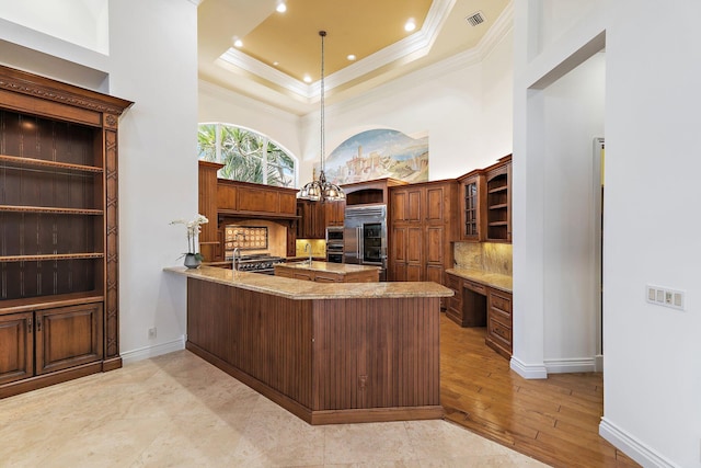 135 Playa Rienta Way, Palm Beach Gardens, FL 33418 - kitchen with built in refrigerator, crown molding, a peninsula, a sink, and decorative backsplash