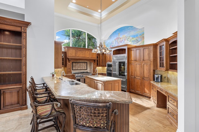 kitchen featuring kitchen peninsula, a breakfast bar, pendant lighting, decorative backsplash, and sink