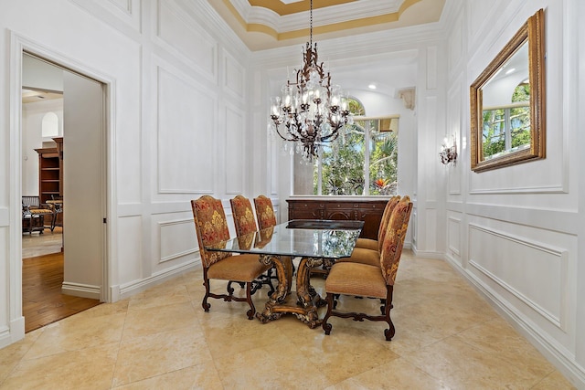 135 Playa Rienta Way, Palm Beach Gardens, FL 33418 - dining space with a decorative wall, a chandelier, ornamental molding, and light tile patterned floors