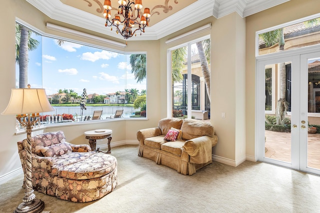 living area featuring carpet flooring, crown molding, and a chandelier