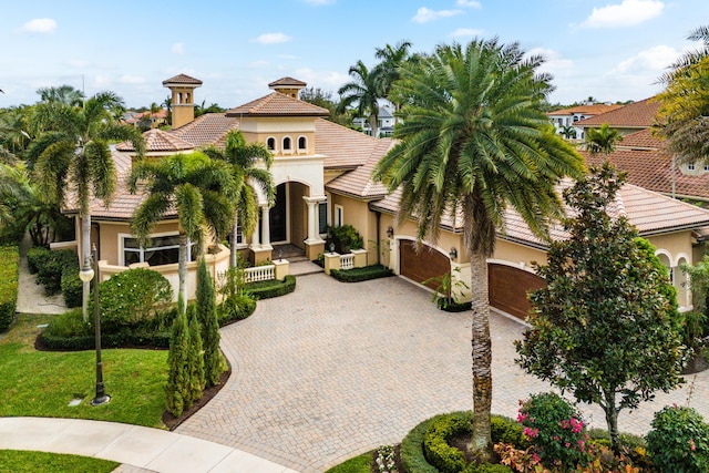 135 Playa Rienta Way, Palm Beach Gardens, FL 33418 - mediterranean / spanish-style house with decorative driveway, stucco siding, a garage, a tile roof, and covered porch
