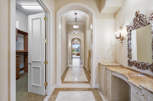 bathroom featuring vanity, ornamental molding, and a notable chandelier