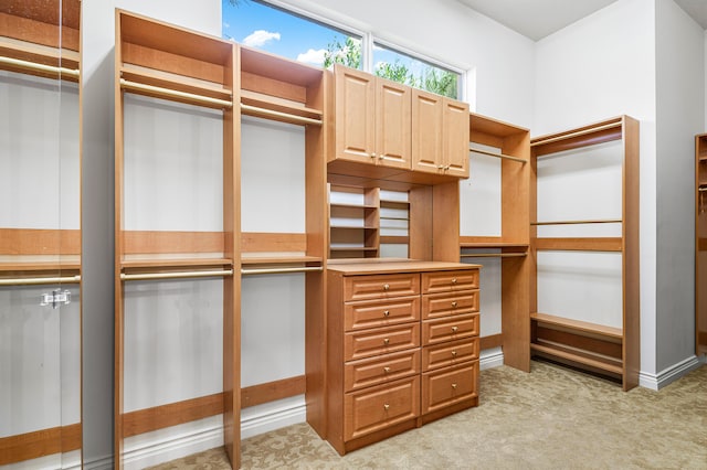 walk in closet featuring light colored carpet