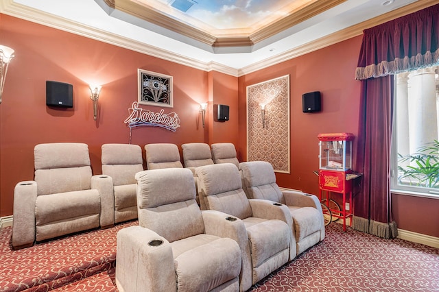 carpeted cinema room featuring a raised ceiling and crown molding