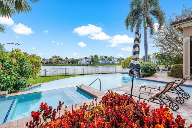 view of pool featuring a patio and a water view