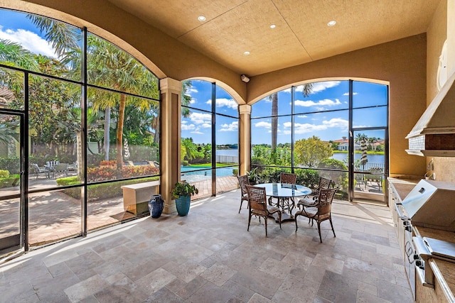 135 Playa Rienta Way, Palm Beach Gardens, FL 33418 - sunroom featuring a water view, stone tile flooring, recessed lighting, and a high ceiling