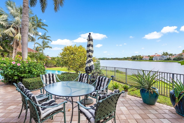 135 Playa Rienta Way, Palm Beach Gardens, FL 33418 - view of patio featuring outdoor dining area, fence, and a water view