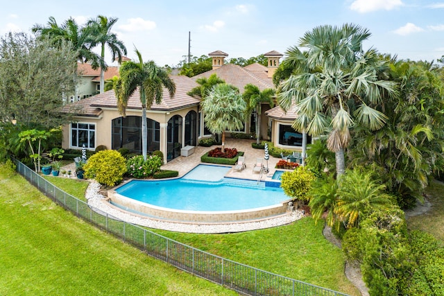 view of swimming pool featuring a patio, a sunroom, and a lawn