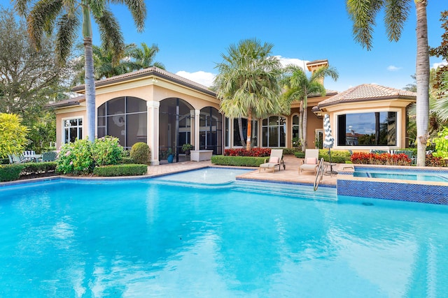 view of swimming pool featuring a sunroom and a patio area