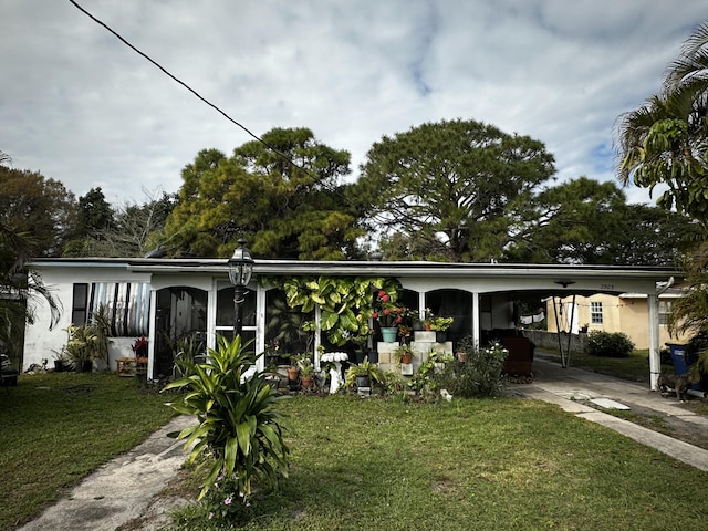 view of front of property with a carport and a front lawn