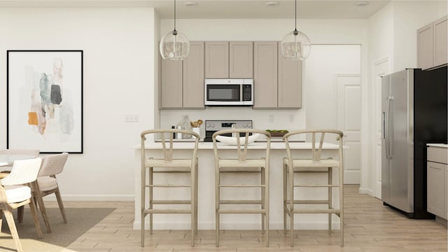 kitchen with a breakfast bar area, gray cabinetry, hanging light fixtures, and stainless steel appliances