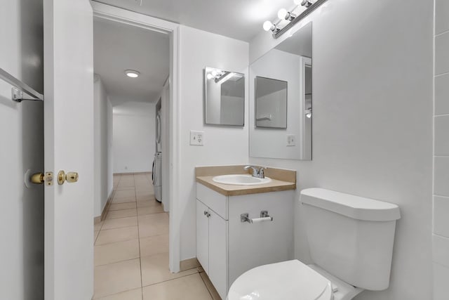 bathroom featuring tile patterned flooring, vanity, washer / clothes dryer, and toilet