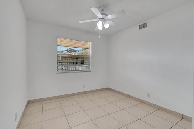 tiled empty room featuring ceiling fan