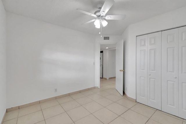 unfurnished bedroom featuring light tile patterned floors, a closet, and ceiling fan