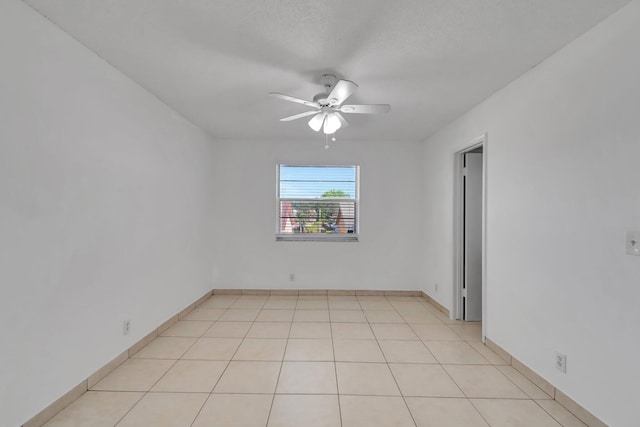 spare room featuring ceiling fan and light tile patterned floors