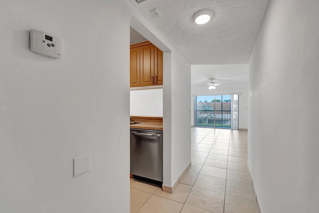 hall with light tile patterned floors and a textured ceiling