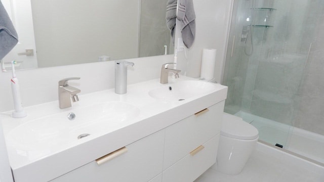 bathroom with vanity, a shower with door, and toilet