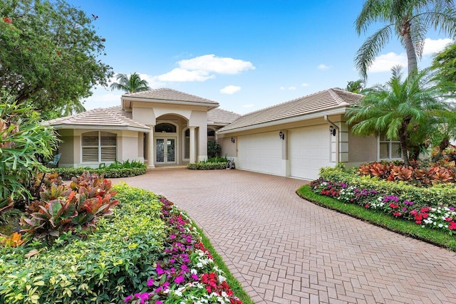 mediterranean / spanish-style house with a garage and french doors