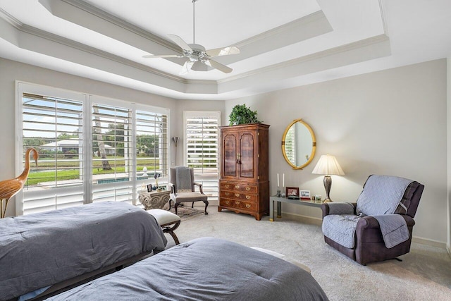 carpeted bedroom with ceiling fan, multiple windows, ornamental molding, and a raised ceiling