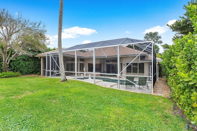 rear view of property featuring a lawn, a patio, and glass enclosure