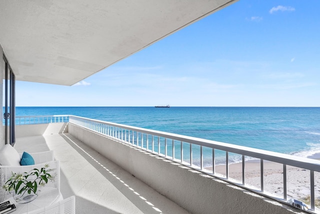 balcony featuring a beach view and a water view