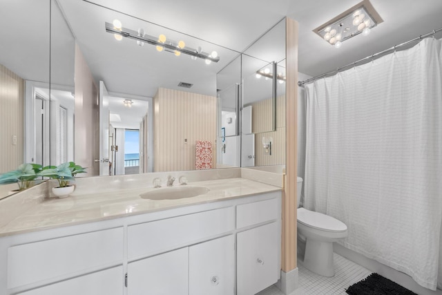 bathroom with tile patterned flooring, vanity, and toilet