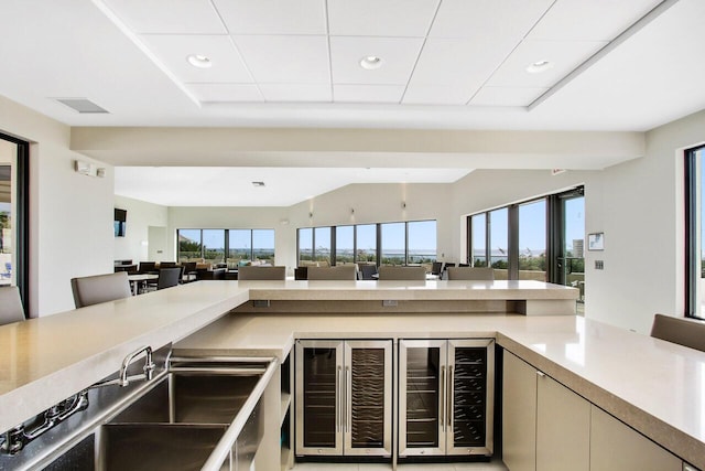 kitchen featuring beverage cooler and cream cabinetry