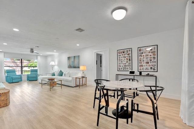 dining space with ceiling fan and light wood-type flooring