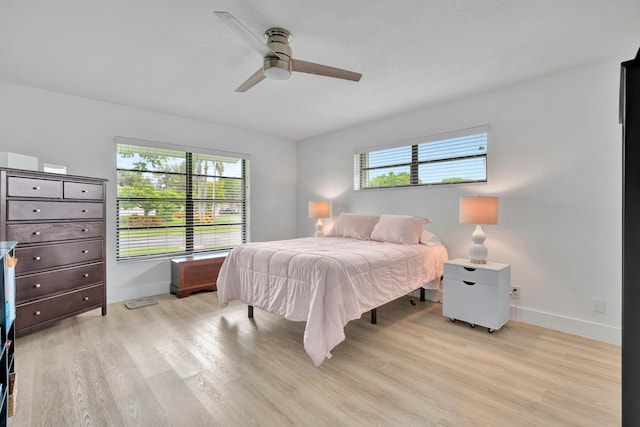 bedroom featuring multiple windows, ceiling fan, and light hardwood / wood-style flooring