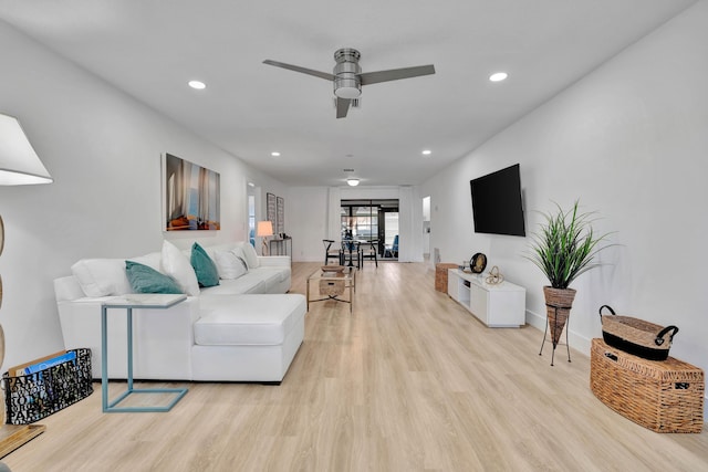 living room with ceiling fan and light hardwood / wood-style floors