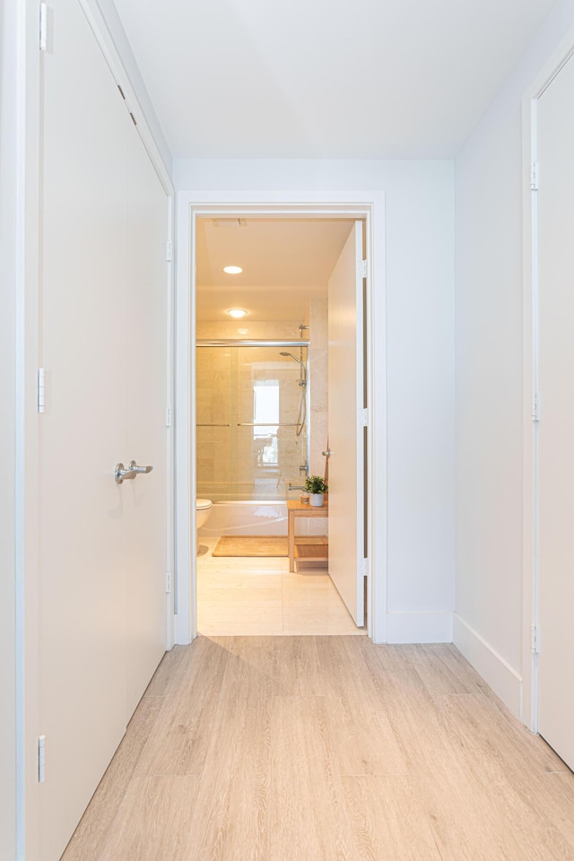 corridor with light hardwood / wood-style flooring