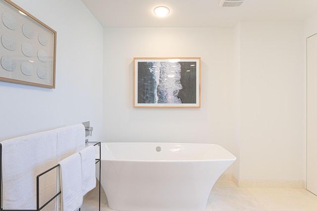 bathroom featuring tile patterned flooring and a tub to relax in