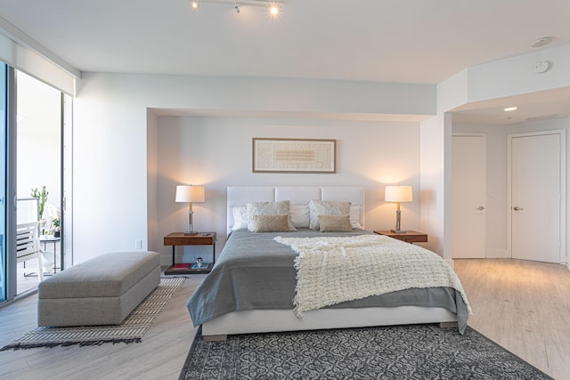 bedroom with light hardwood / wood-style floors and expansive windows