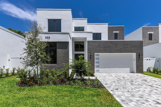 contemporary house featuring a front yard and a garage