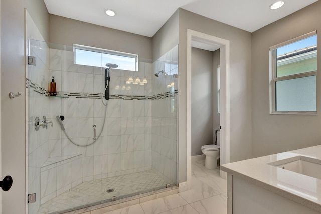 bathroom featuring walk in shower, vanity, toilet, and a healthy amount of sunlight