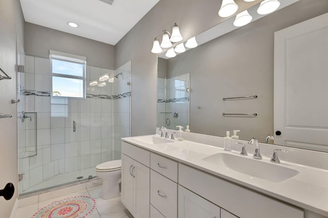 bathroom featuring a shower with shower door, vanity, tile patterned flooring, and toilet